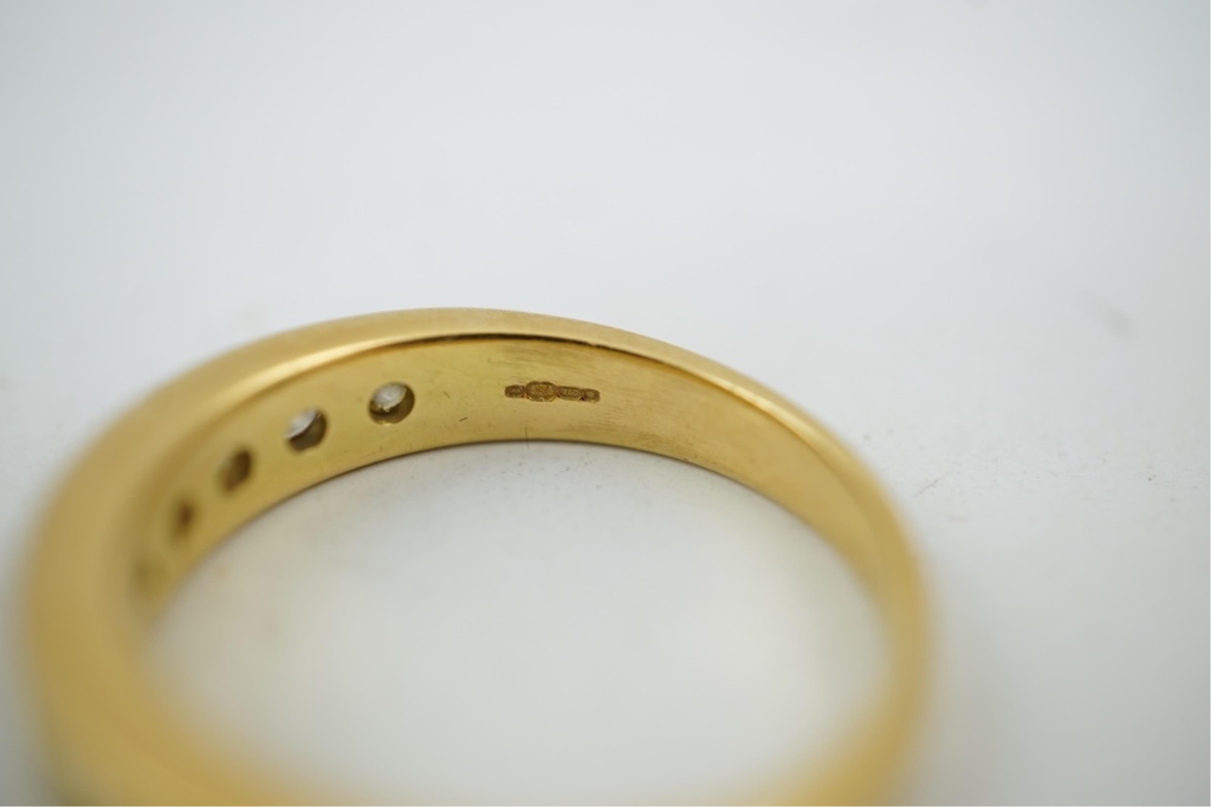 A modern 18ct gold and channel set graduated ten stone diamond set half eternity ring, size Q, gross weight 5.4 grams.